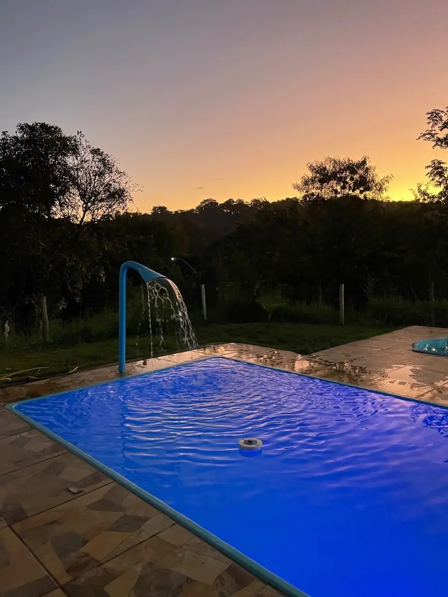 Piscina iluminada ao pôr do sol no Espaço Emerson